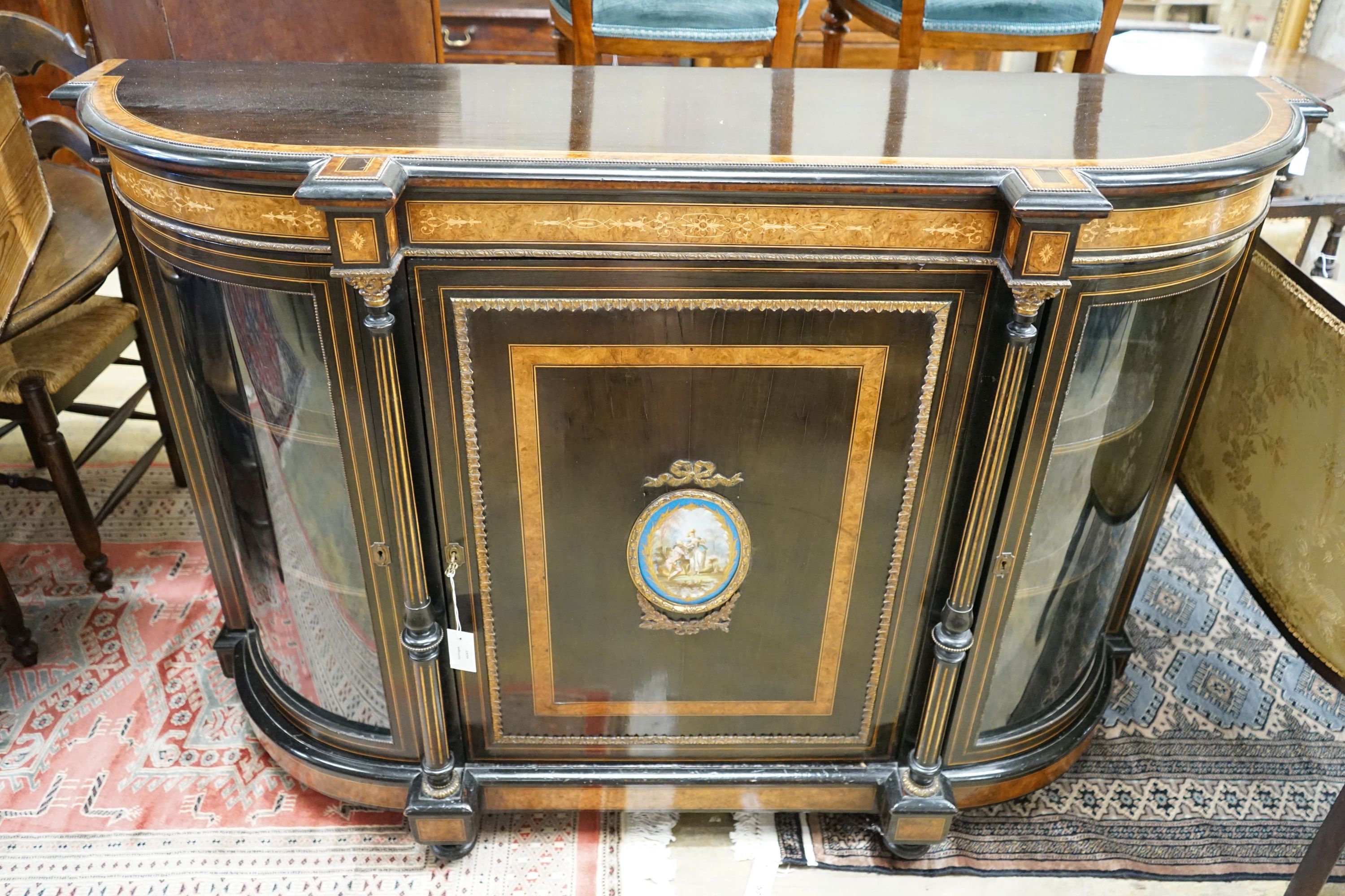 A late Victorian ebonised and amboyna banded credenza, with inset Sevres style porcelain panel, width 154cm, depth 45cm, height 107cm